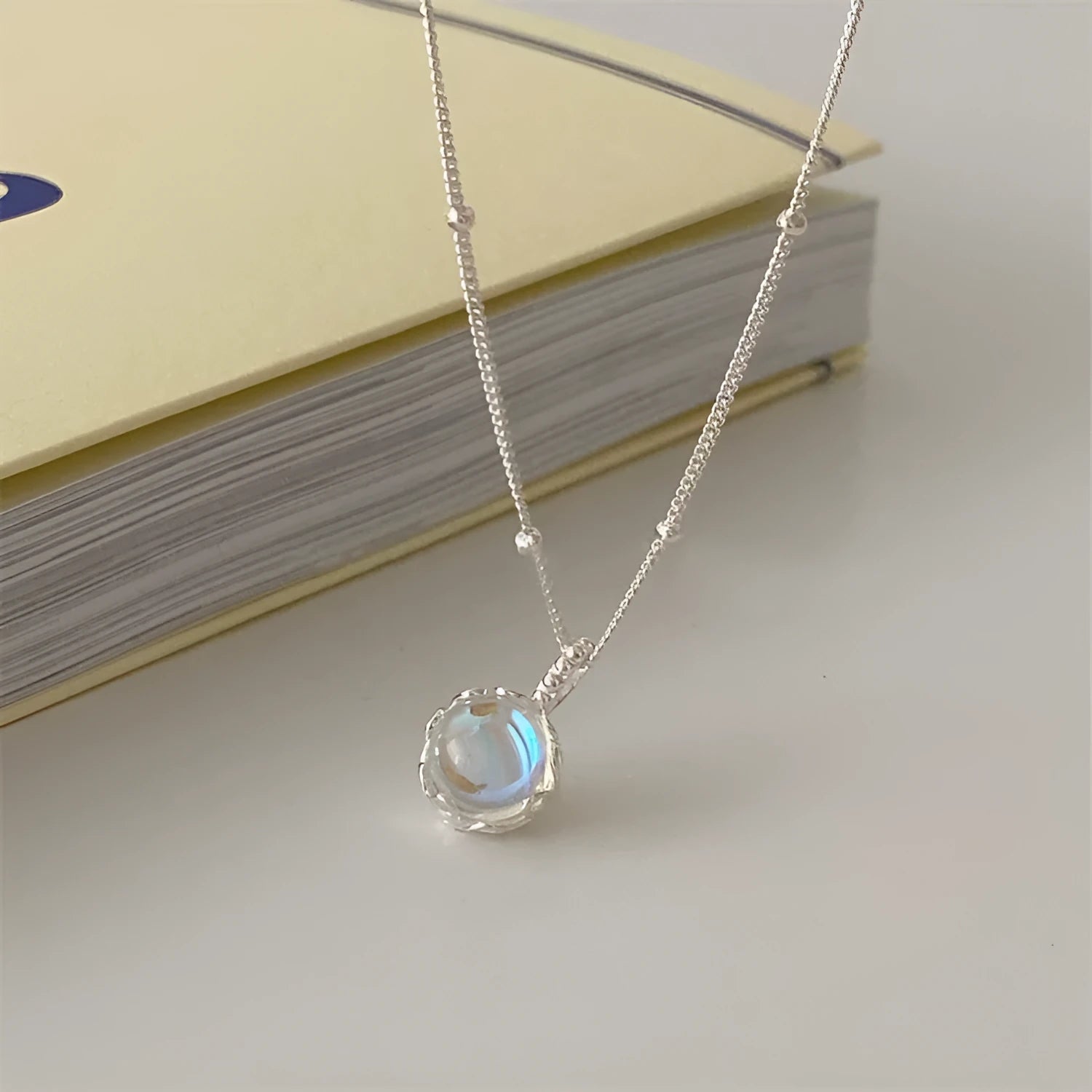 Round geometric 925 silver ornamental stone pendant on a silver curb chain necklace for women.