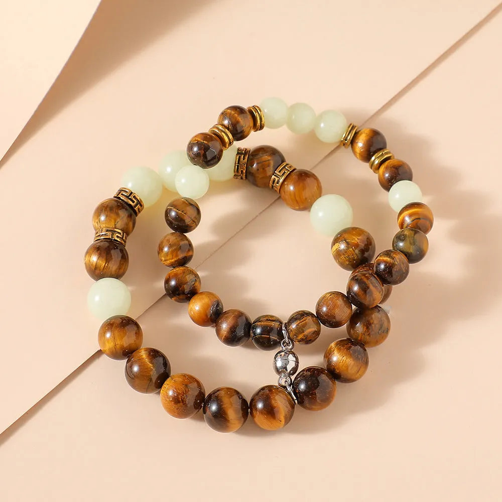 A pair of amber-coloured geometric resin bracelets with a luminous glow, shown together.