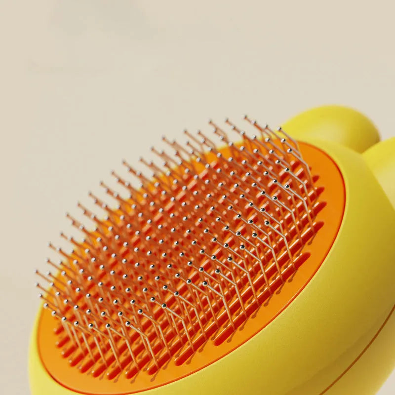 Self-cleaning pet brush with green handle and stainless steel teeth, showing release button mechanism