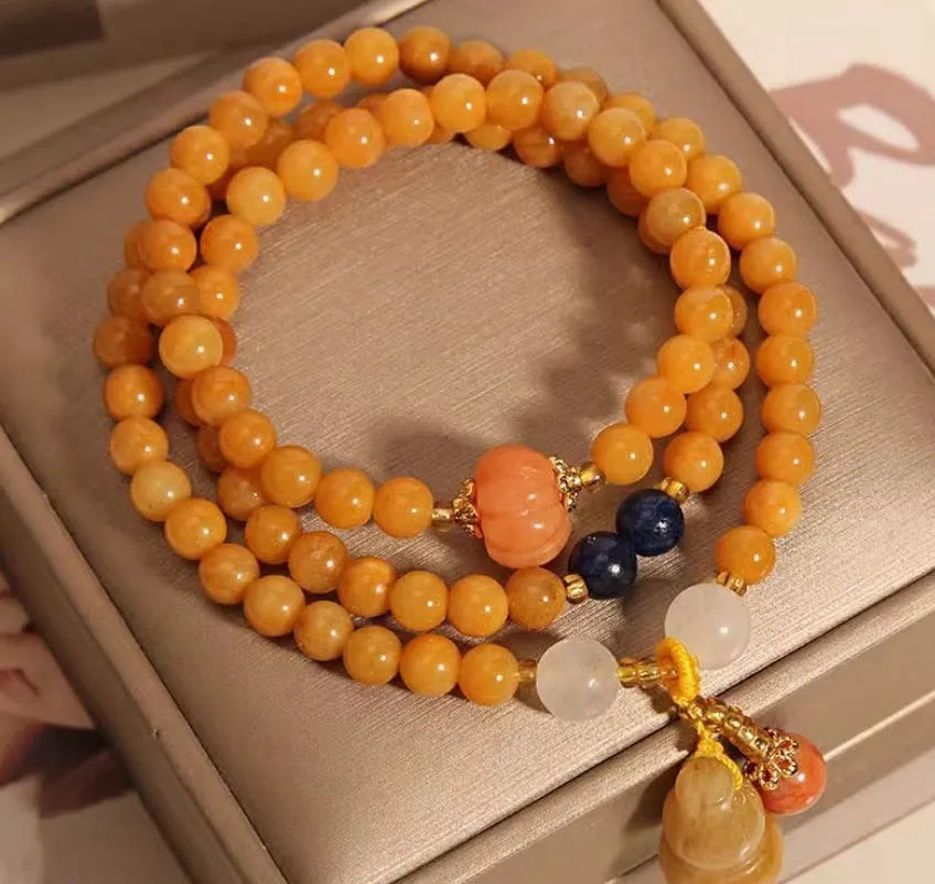 Women's multi-circle bracelet with three strands of natural Jinsi Jade beads and a resin flower calabash pendant on a white background