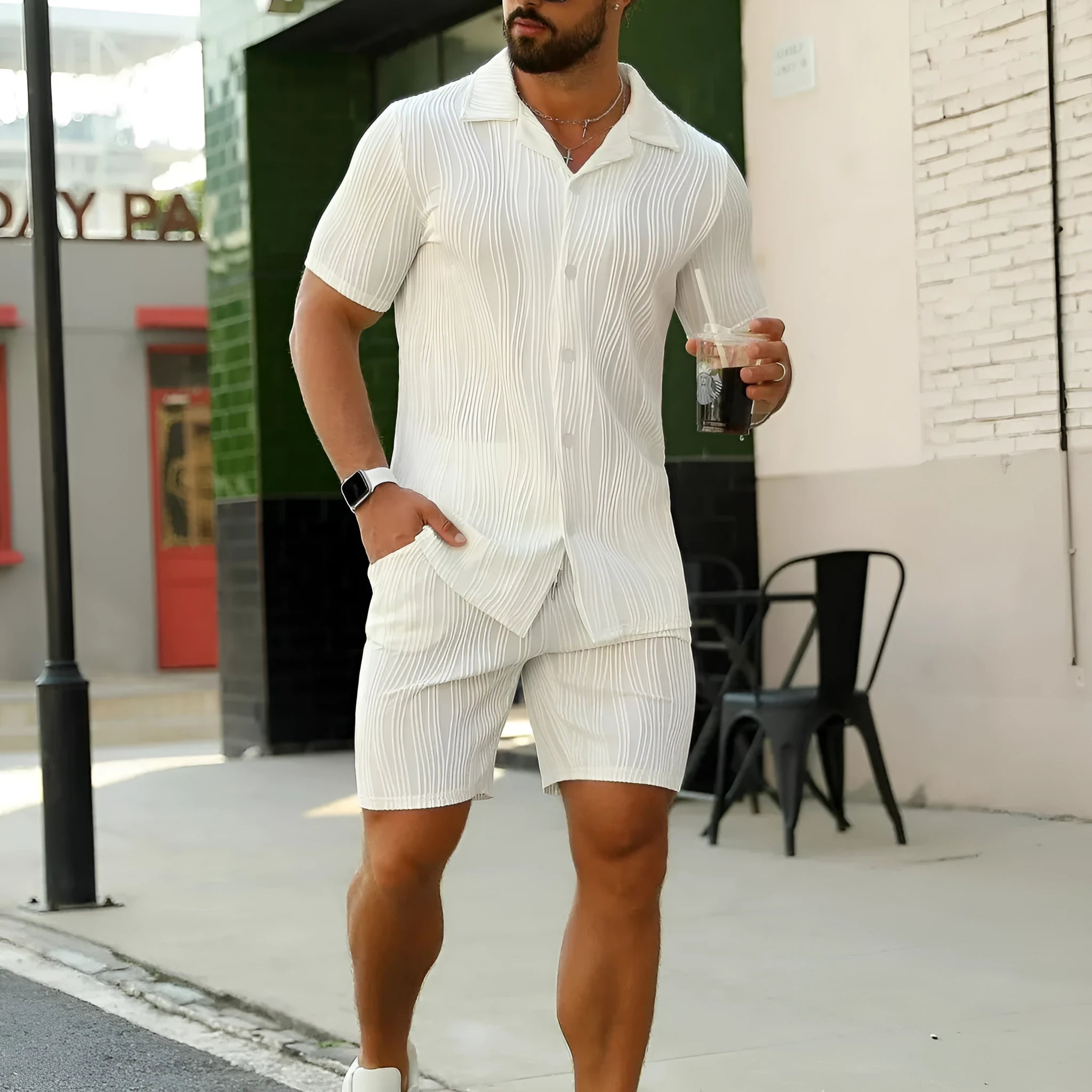Men's black wave pattern short sleeve top and matching shorts casual set on a hanger.