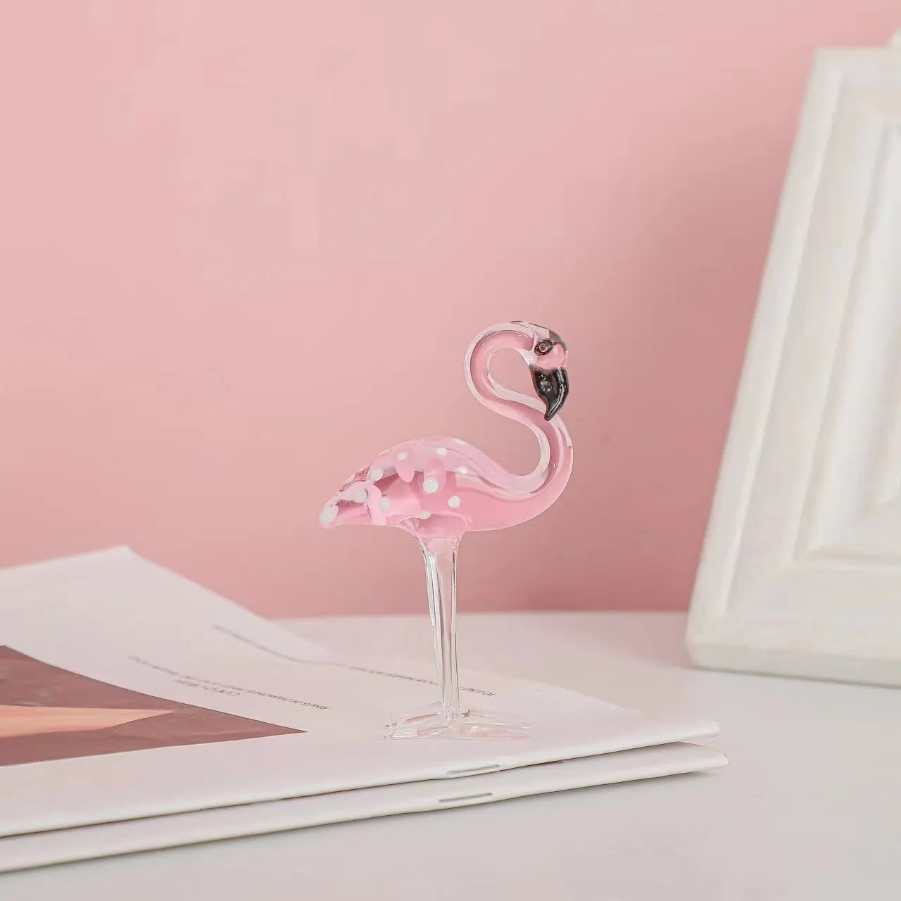 Pink crystal simulation flamingo decorative ornament on a table for home decor or gifting.