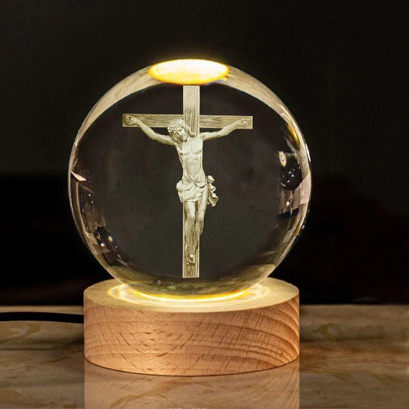White crystal ball ornament with internal Christian cross figure on a wooden light-up base.