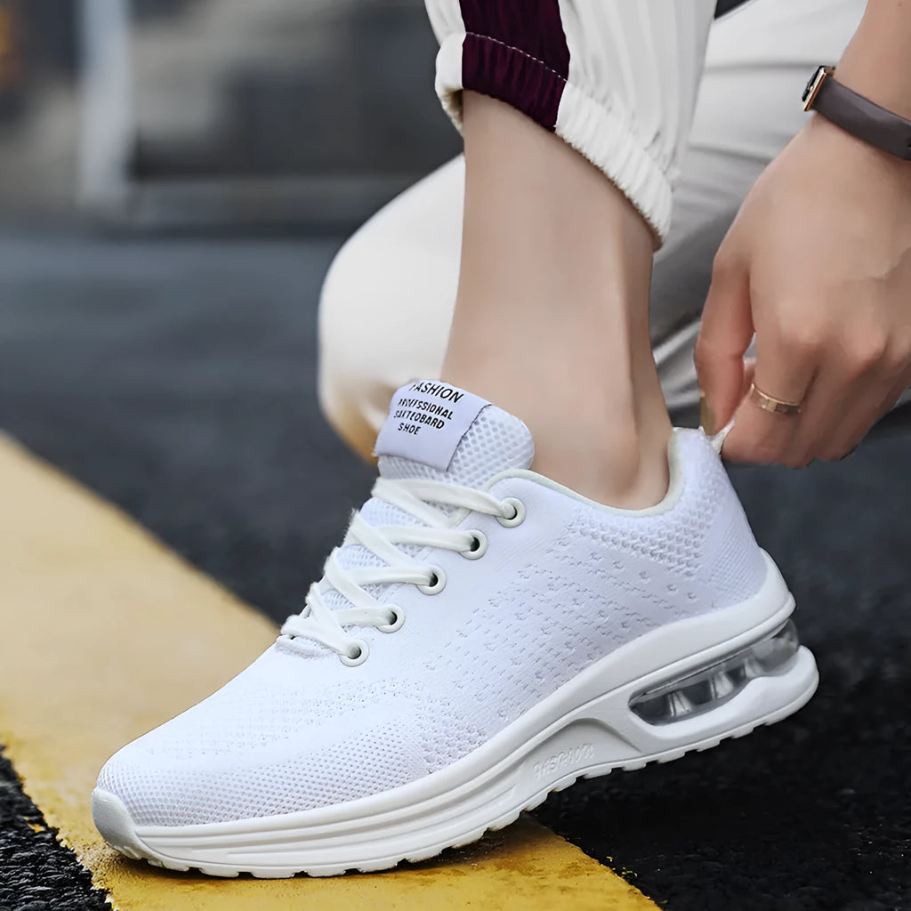 Pair of grey and black Flyknit mesh running shoes with a round toe and PU sole on a white background.