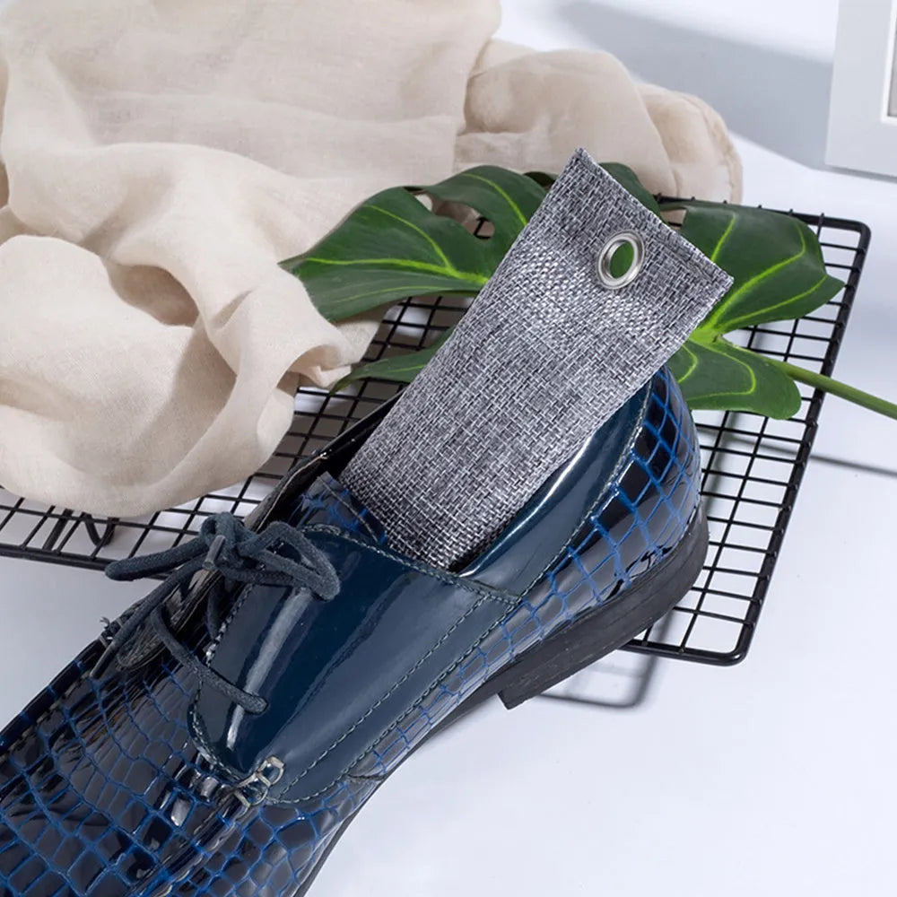 Black, green, grey and blue activated charcoal shoe deodoriser bags measuring 16.5cm.