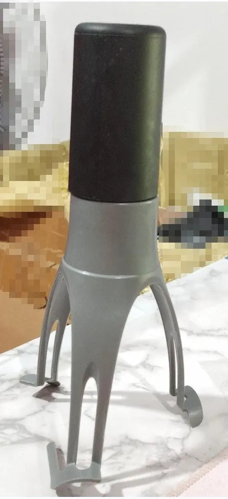 Green Uutensil Stirr automatic cooking mixer device next to a cooking pot.
