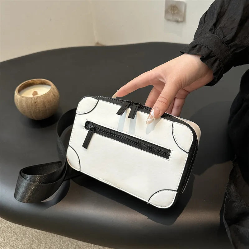 Small square women's crossbody bag in PU leather, shown in street-trend style with a single strap.