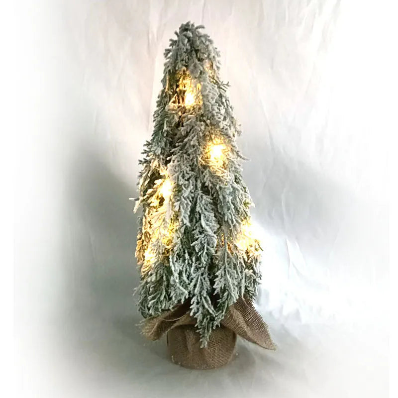 Small 24-inch artificial Christmas tree with lights and snow finish on desktop