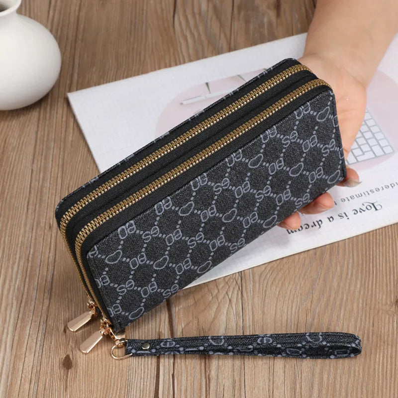 Black retro print long wallet clutch bag with zipper, holding a mobile phone and cards.