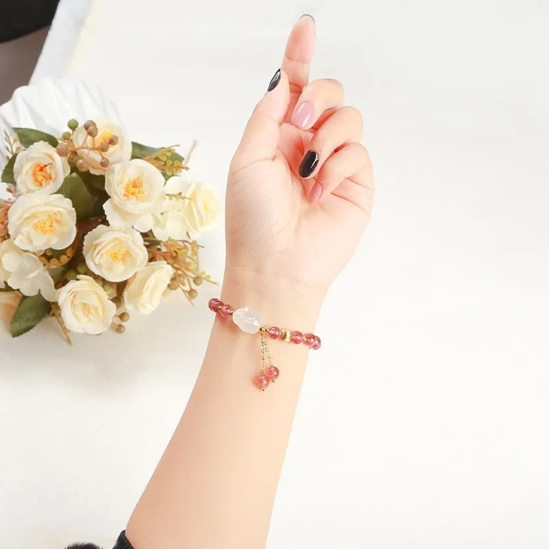 Women's strawberry quartz and agate bracelet with 6mm round beads and a white rabbit charm pendant.