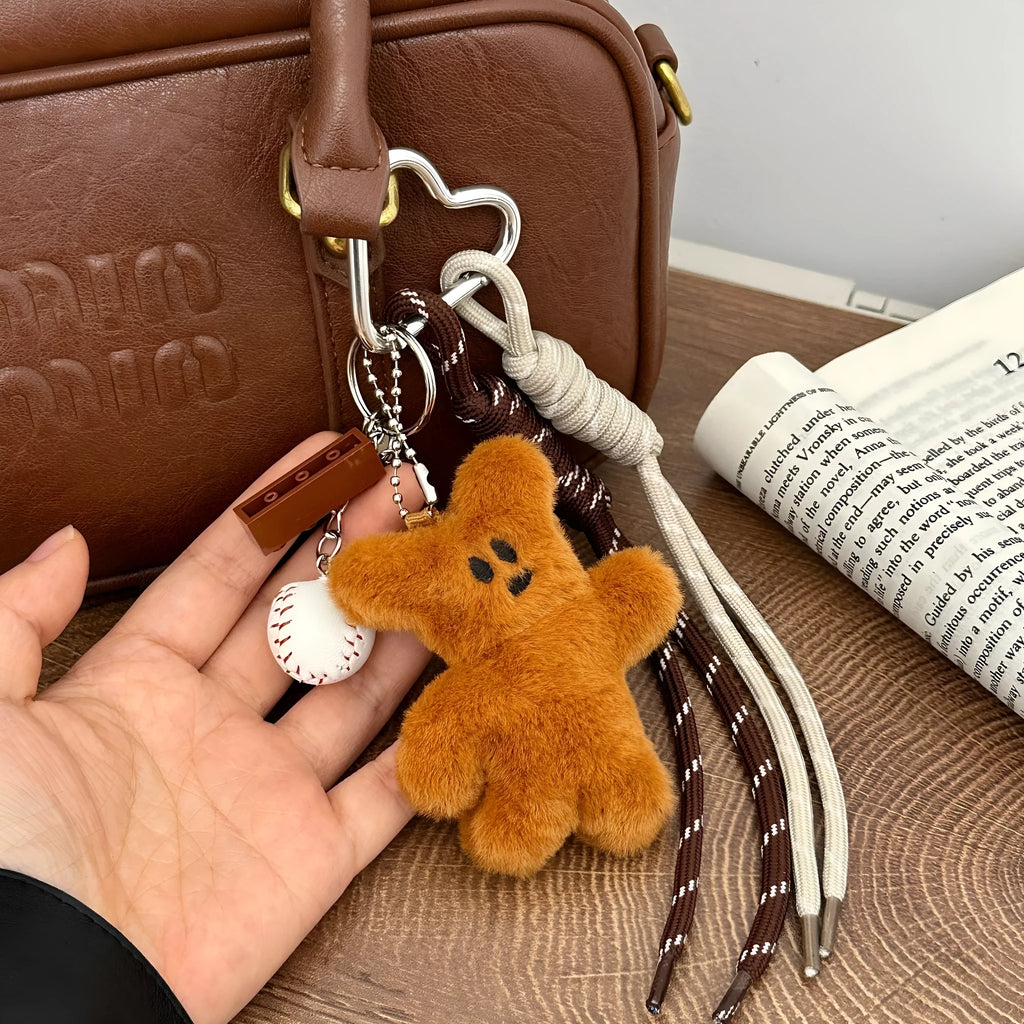 Soft plush brown bear doll pendant keychain hanging on a bag, with a cute bear/piglet animal pattern