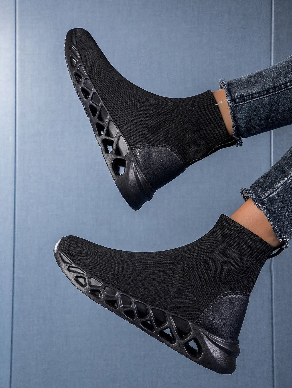 Women's black mesh slip-on casual shoe with a low-top, sock-like ankle design and flat sole.