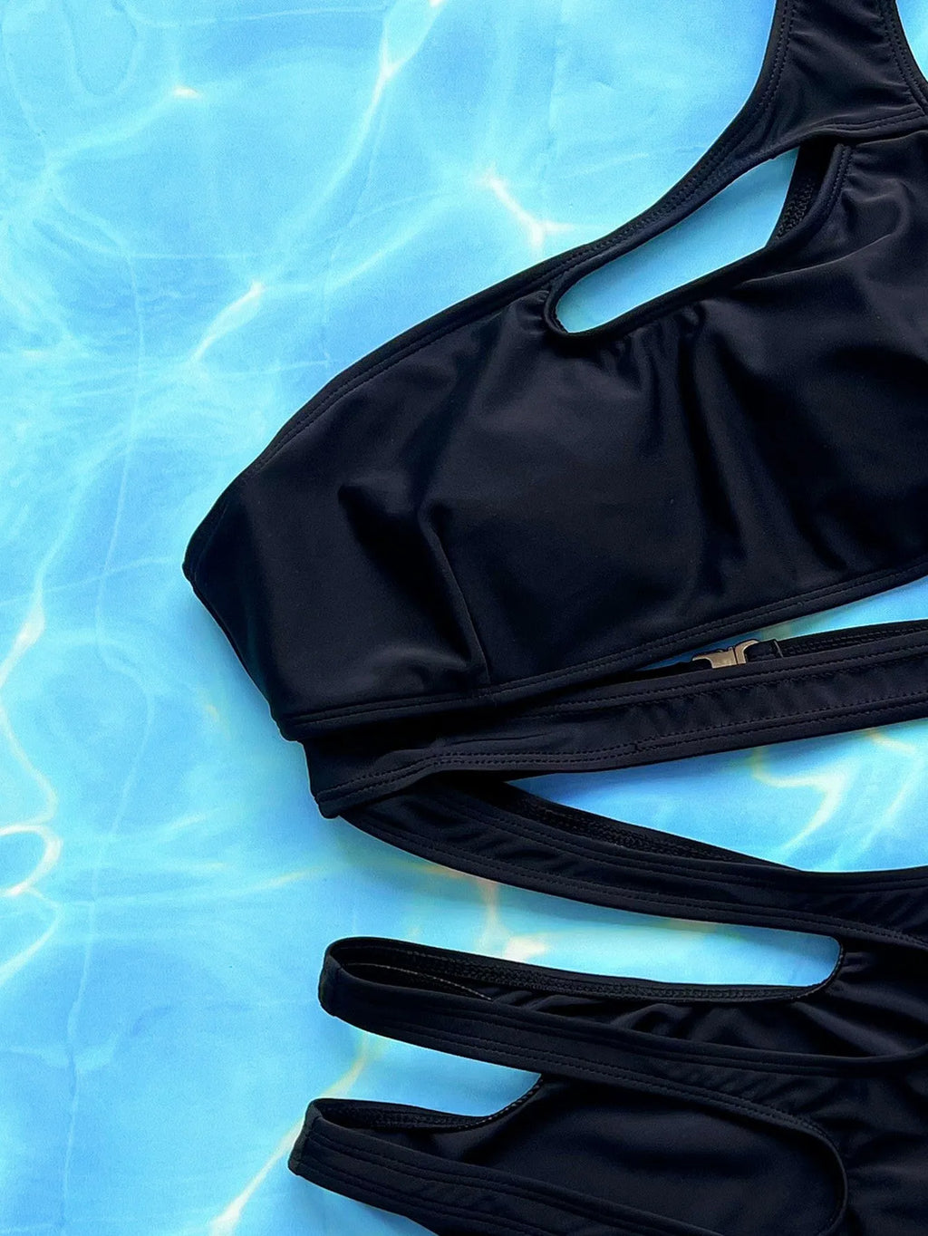 Women's solid black one-piece swimsuit with hollow-out strap design showing front view