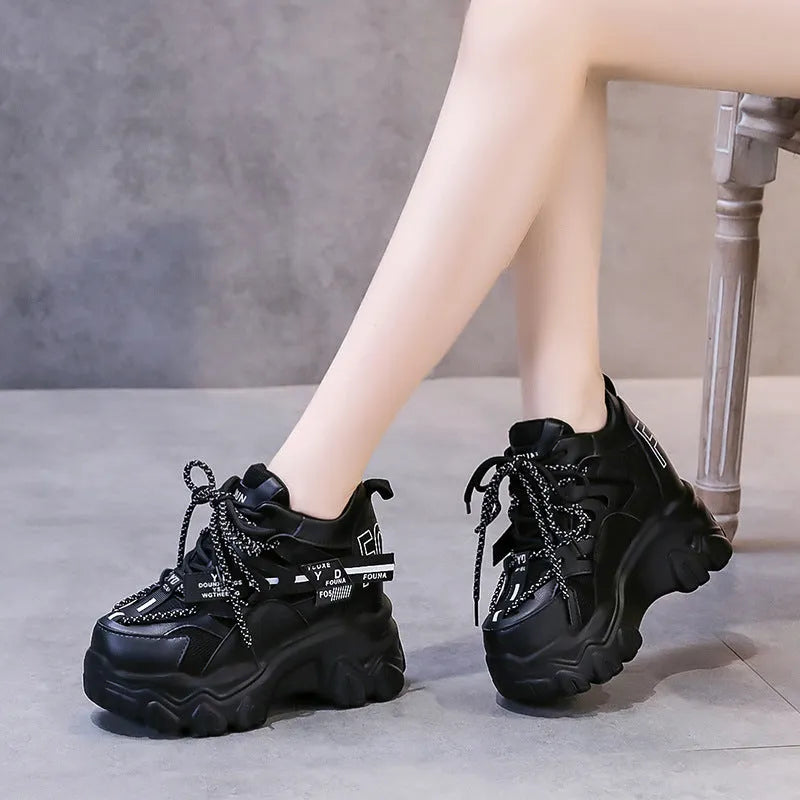 White women's low-top platform sports shoes with cross-strap and round toe on a rubber sole.