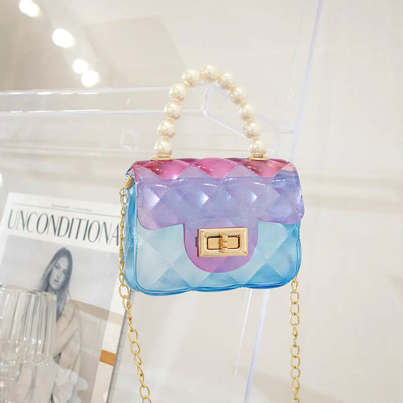 Mini kids crossbody bag in soft PVC with horizontal square shape, available in six colours including yellow, green, blue, black, and pink.