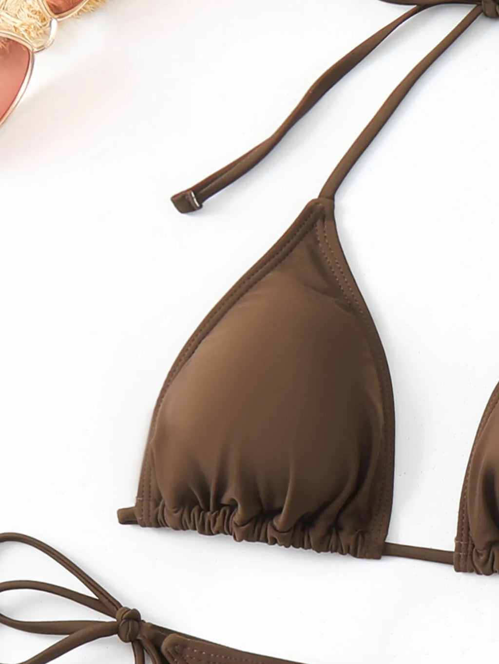 Brown women's three-piece bikini set showing bra, shorts, and blouse laid flat.