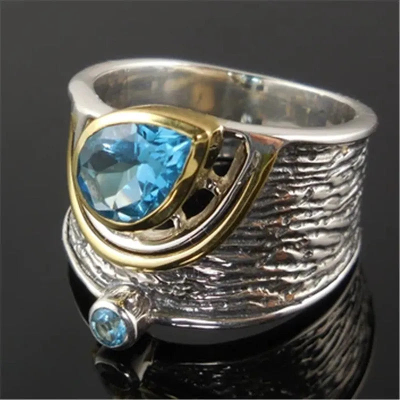 Blue drop-shaped women's alloy ring with inlaid zircon rhinestones on a finger.