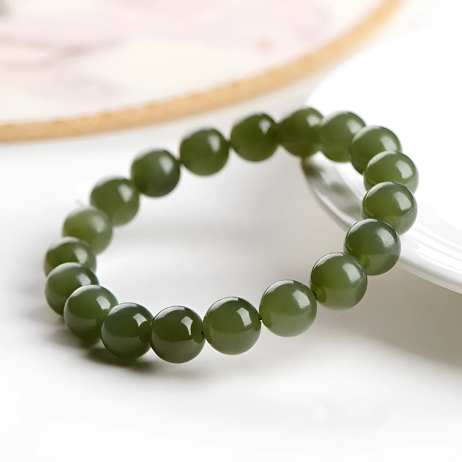 Polished Hetian jade ball bracelet showing different bead sizes on a wrist, in clear ice-like colours.