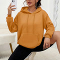 Women's loose fit grey hooded sweatshirt with front pocket and long sleeves on a hanger.