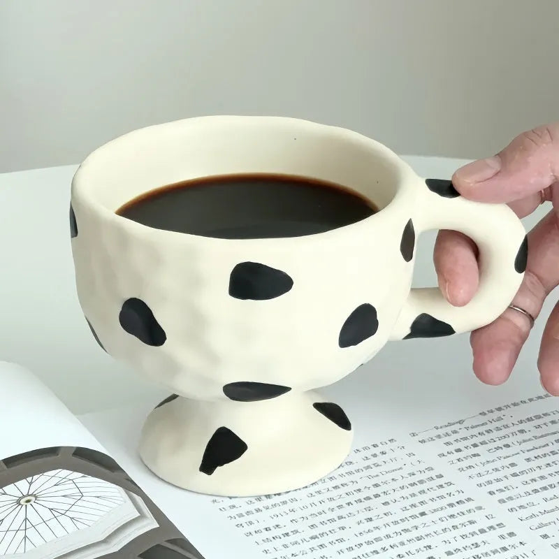 Hand-pinched irregular ceramic mug in a solid colour, showing its unique shape.