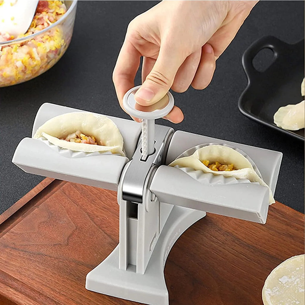 White double head manual dumpling press mould with anti-slip rubber base on kitchen counter.