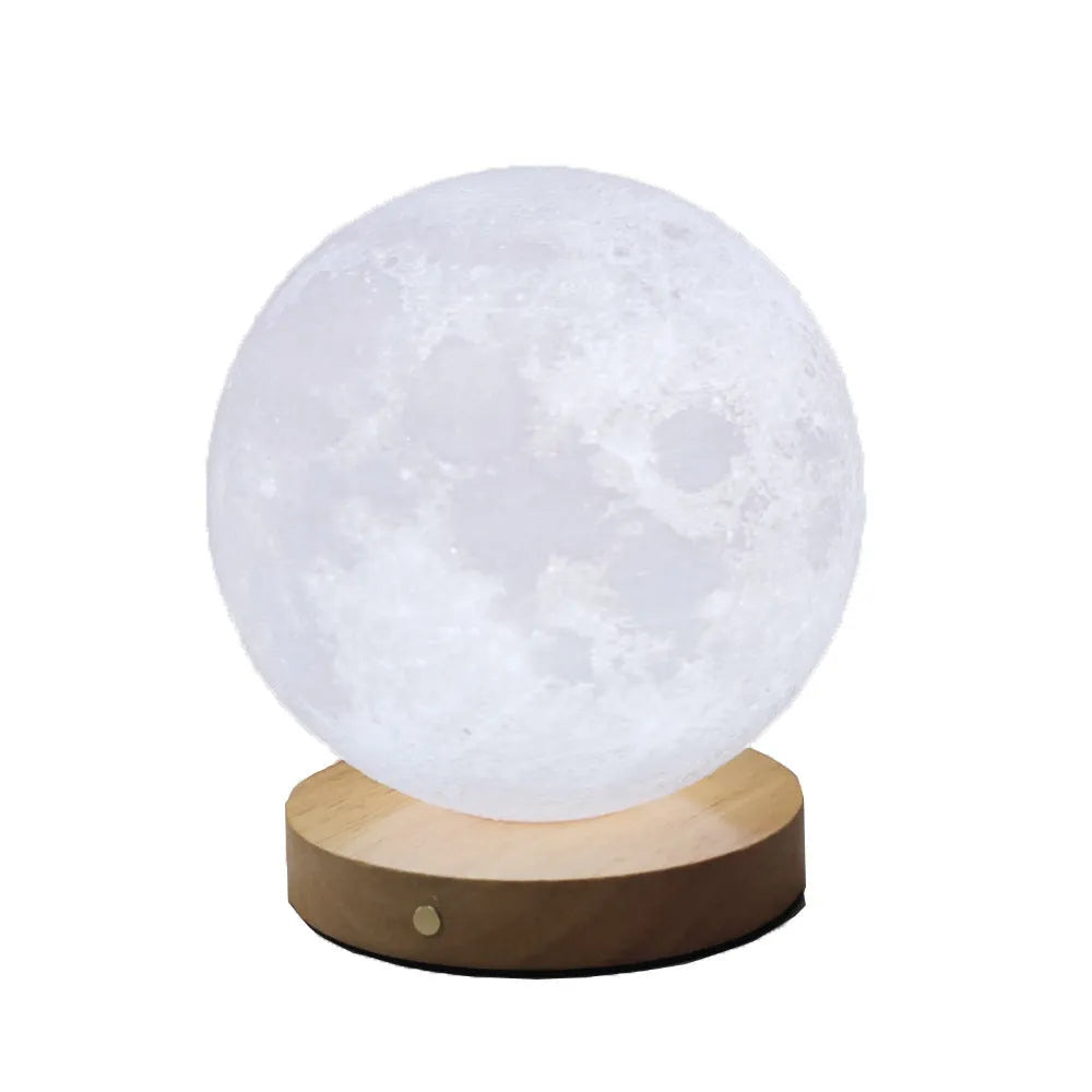 Rotating moon night lamp with wooden base on a table, showing three colour settings and remote control.
