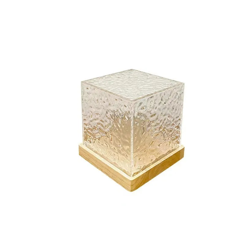 Rotating crystal table lamp projecting blue water ripple light pattern on wall