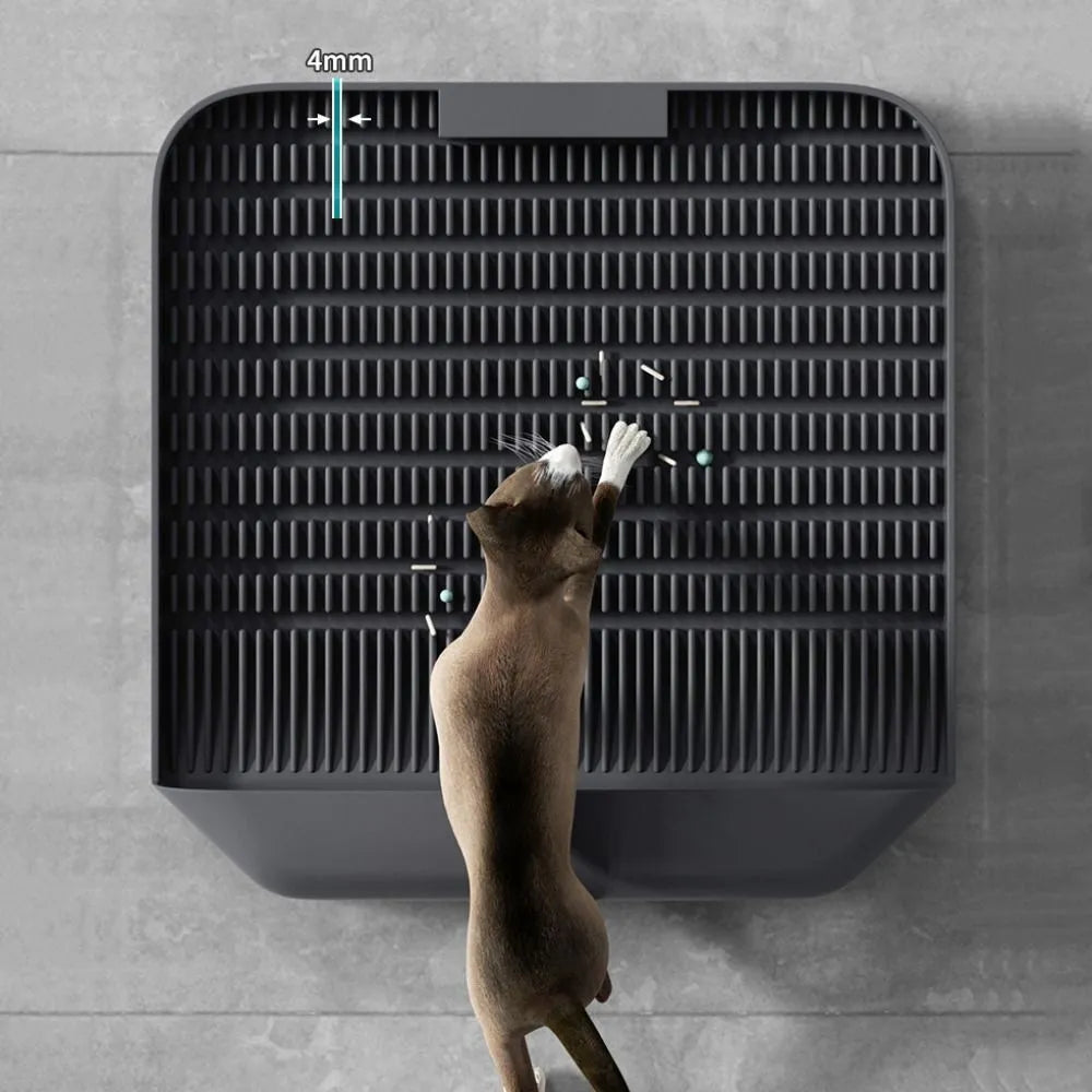 Large black cat litter pedal with slanted mouth and textured non-slip mat next to litter tray