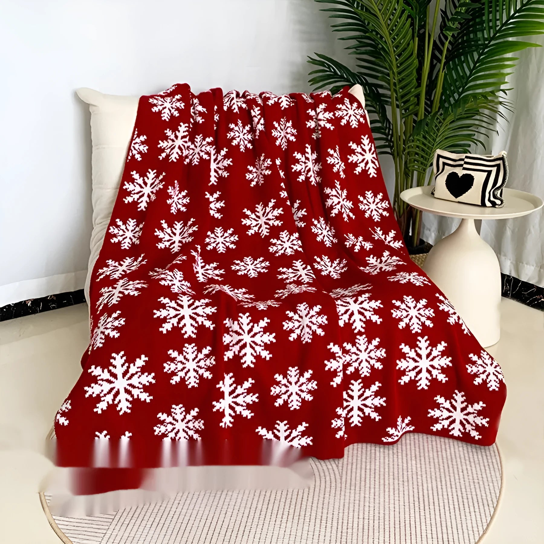 Personalised Christmas blanket with snowflake or reindeer pattern on a sofa.