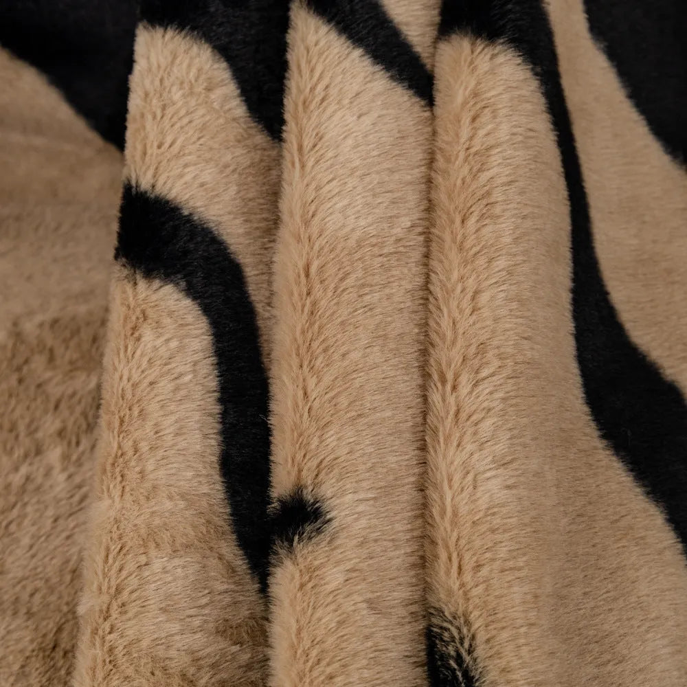 Zebra pattern flannel sofa cover draped over a sofa, showing non-slip underside and matching pillowcase.