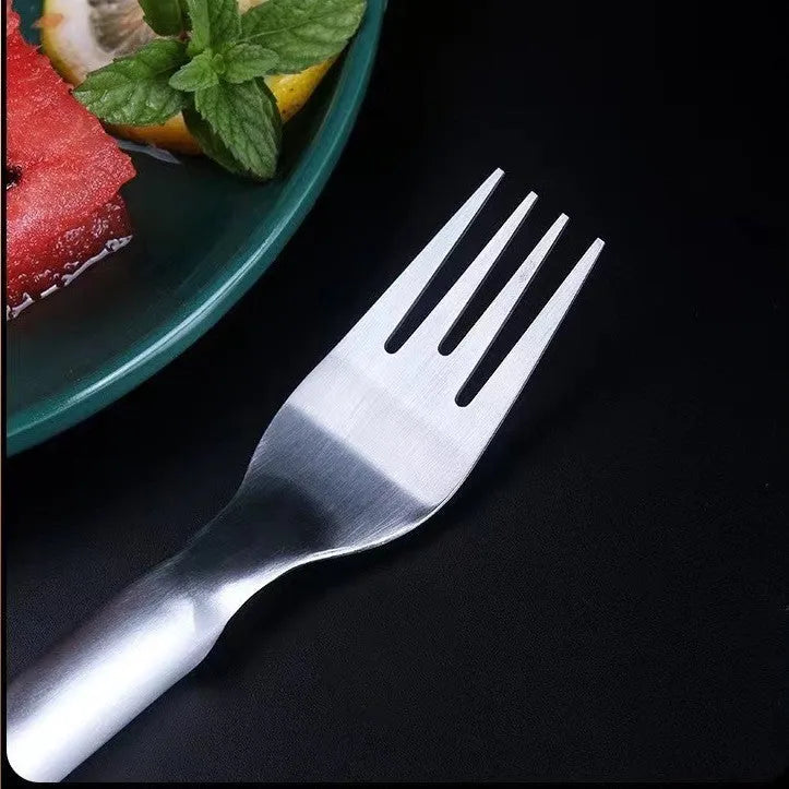 Silver stainless steel watermelon slicer and serving fork with a long handle on a kitchen surface