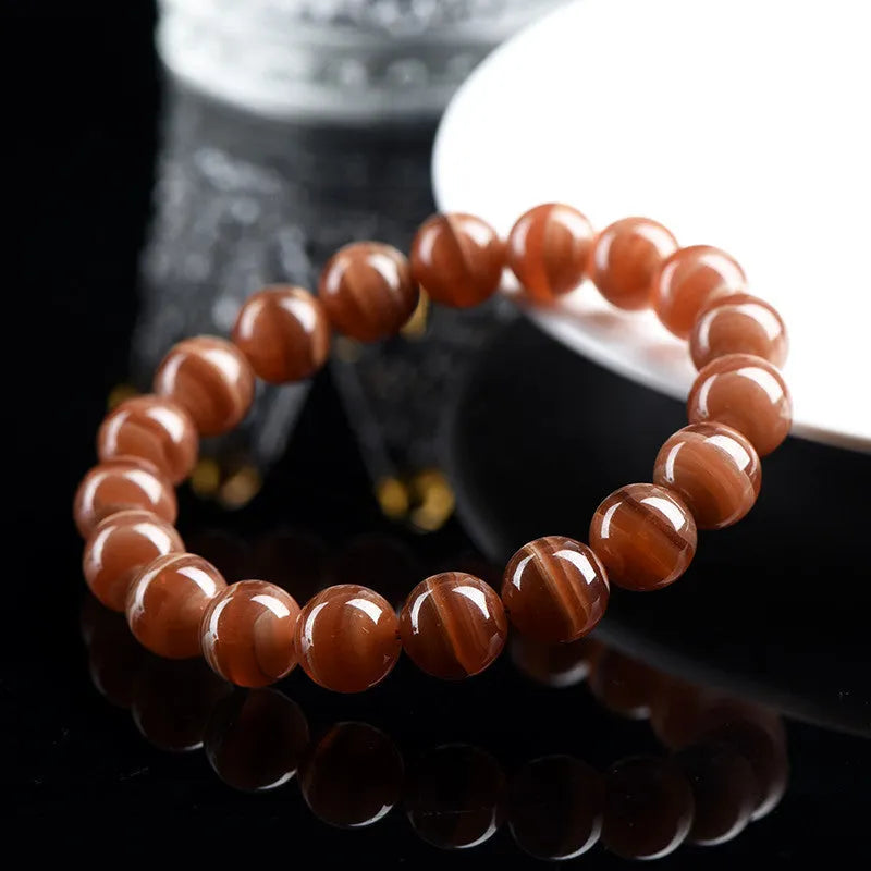 Natural old mine rhodochrosite round bead bracelet with Ruyi charm, shown in 6mm and 8mm sizes.
