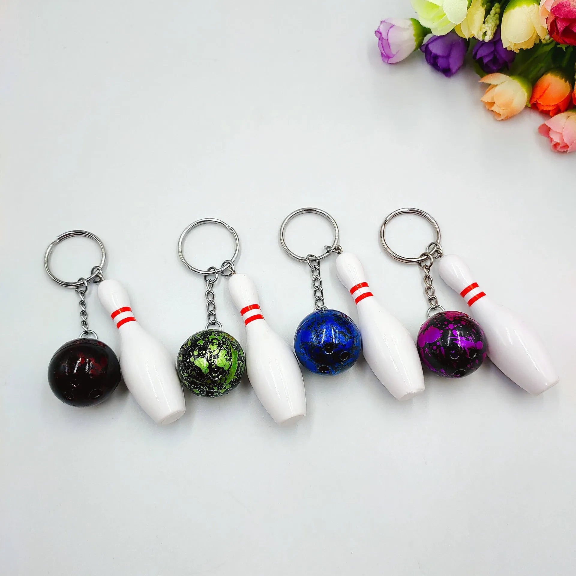 Mini simulation sports bowling ball keychain pendant in dark red, blue, purple, and green colours.
