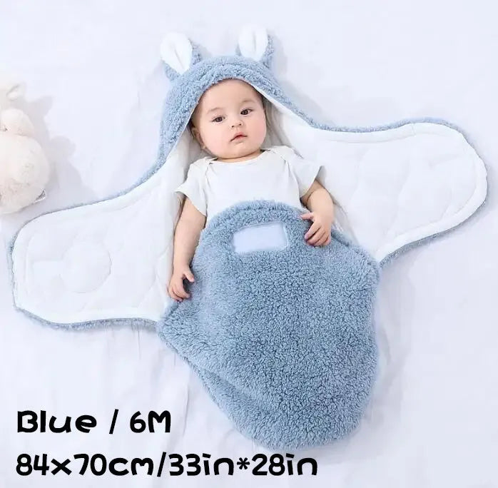 A baby wearing a soft grey fleece sleeping bag with hook-and-loop shoulder straps.