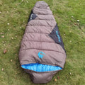 Army green cotton-filled camping sleeping bag with compression storage sack.