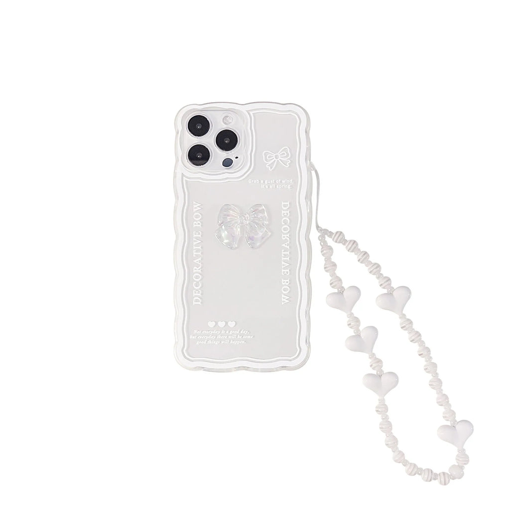 Clear iPhone case with a raised 3D transparent bow design on the back, shown with a white fabric lanyard.