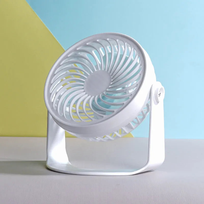Mini USB desk fan with clip attachment and three blades, shown in desktop setting.