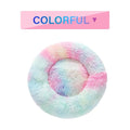 Fluffy donut-shaped dog bed in long plush fabric, shown in a light grey colour with raised edges.