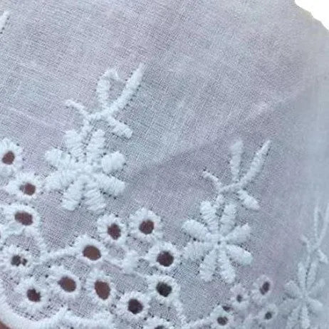 Cotton embroidered lace trim on roll showing cutout pattern, with width measurement examples
