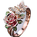 Colourful oil drip finish fairy style alloy ring with butterfly and floral motifs on an adjustable band.