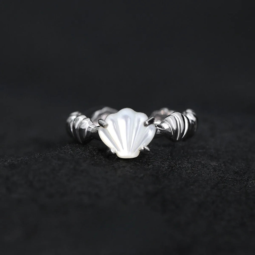 Women's silver ring with shell design and Tiger Eye stone on an adjustable band.