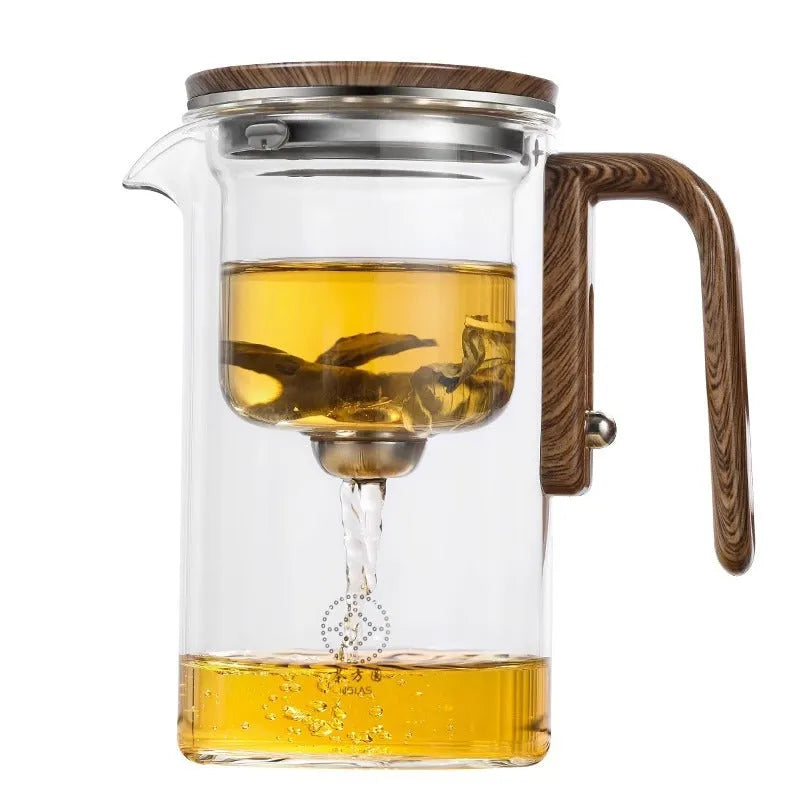 Glass teapot with wooden handle showing magnetic tea separation button and detachable inner infuser.