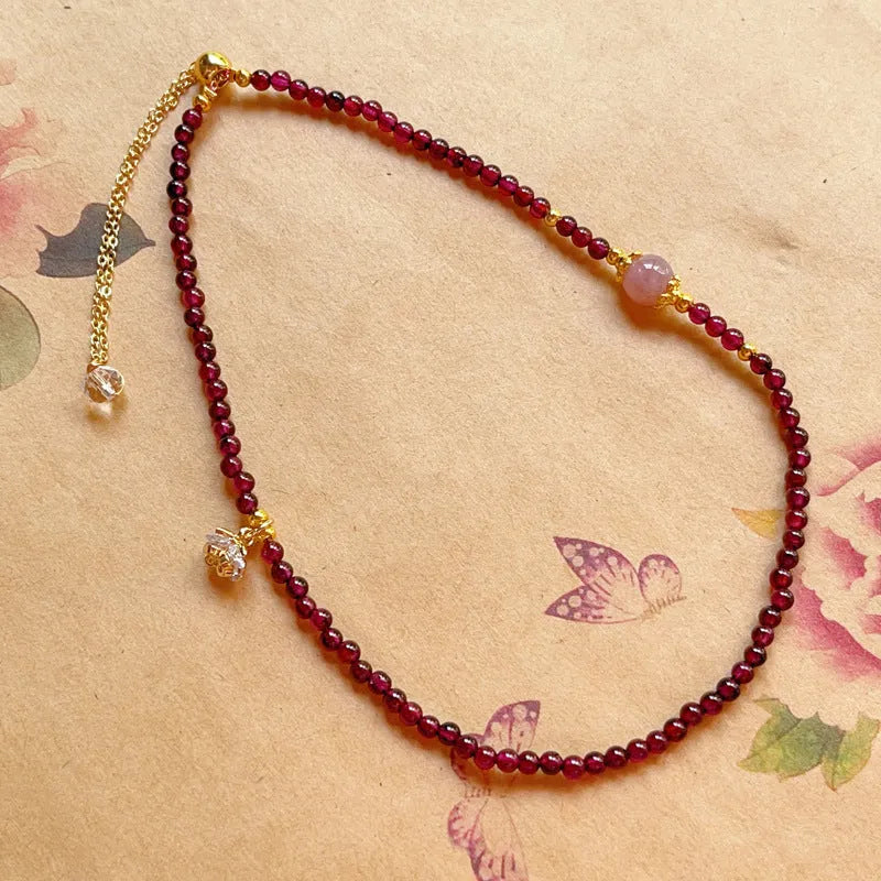 Close-up of a handmade women's natural garnet double ring bracelet in garnet colour.