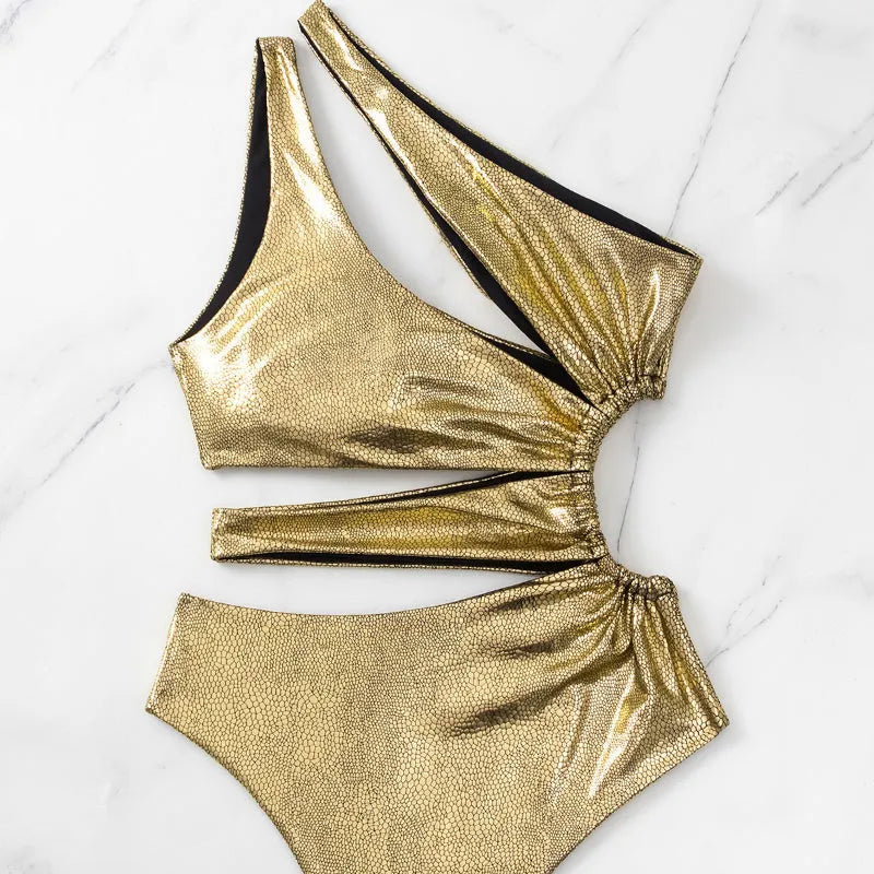 Gold backless one-piece swimsuit for women on a neutral background