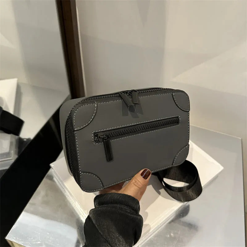 Small square women's crossbody bag in PU leather, shown in street-trend style with a single strap.