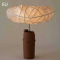 Retro modern table lamp with metal base and fabric shade on a wooden desk