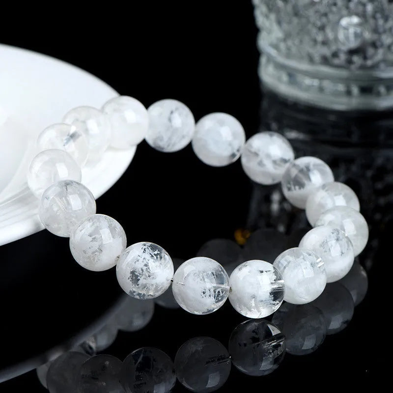Geometric natural blizzard snowflake crystal women's bracelet with round beads on a white background.