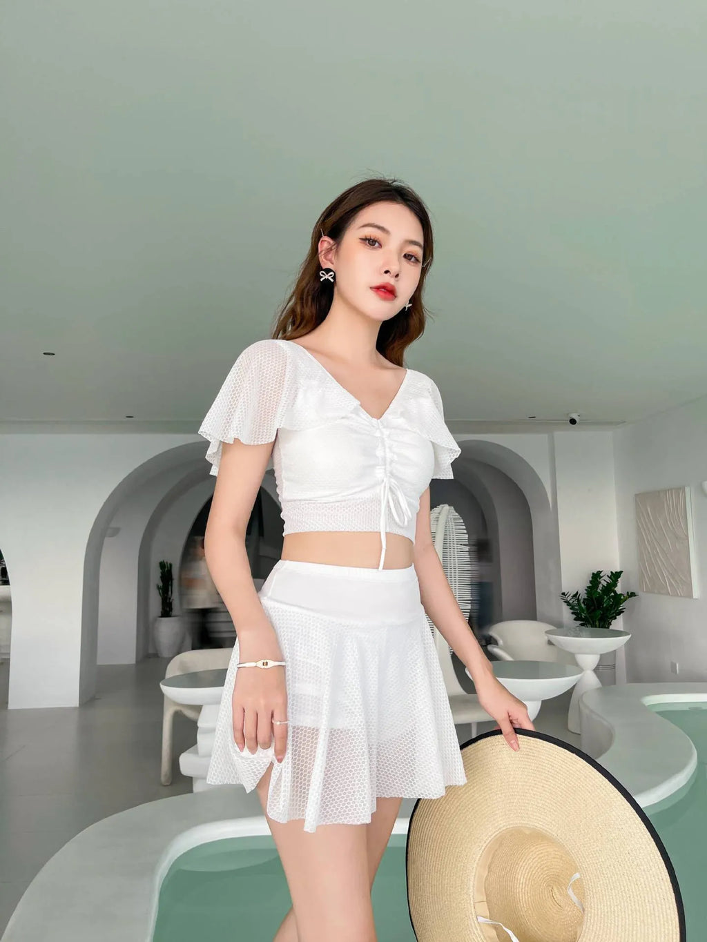 Women's solid colour two-piece swimsuit set with a skirt, shown in white, black, or pink.