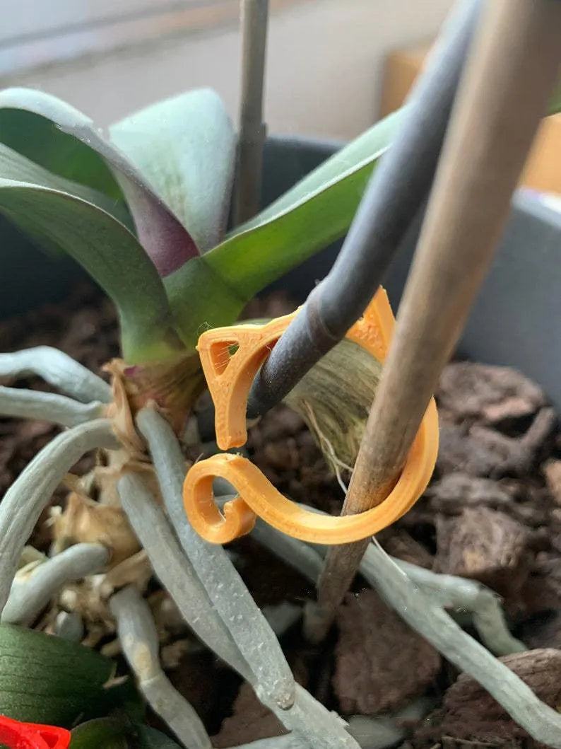 Colourful cat-shaped plastic plant clip for garden use on a white background.