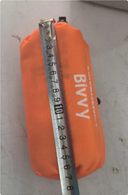 Orange and green emergency tents with sleeping bags and survival whistle for outdoor disaster relief
